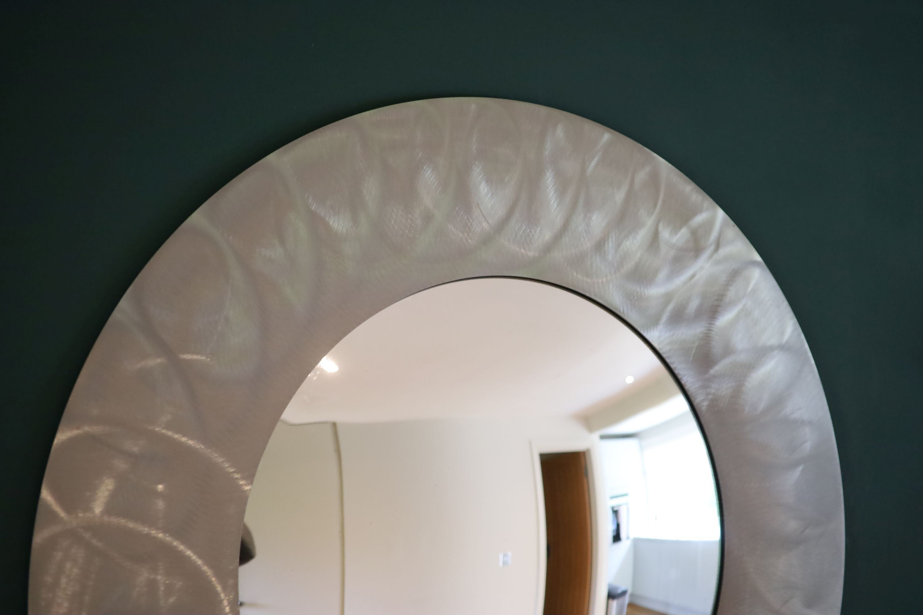 A brushed steel circular wall mirror, 96cm